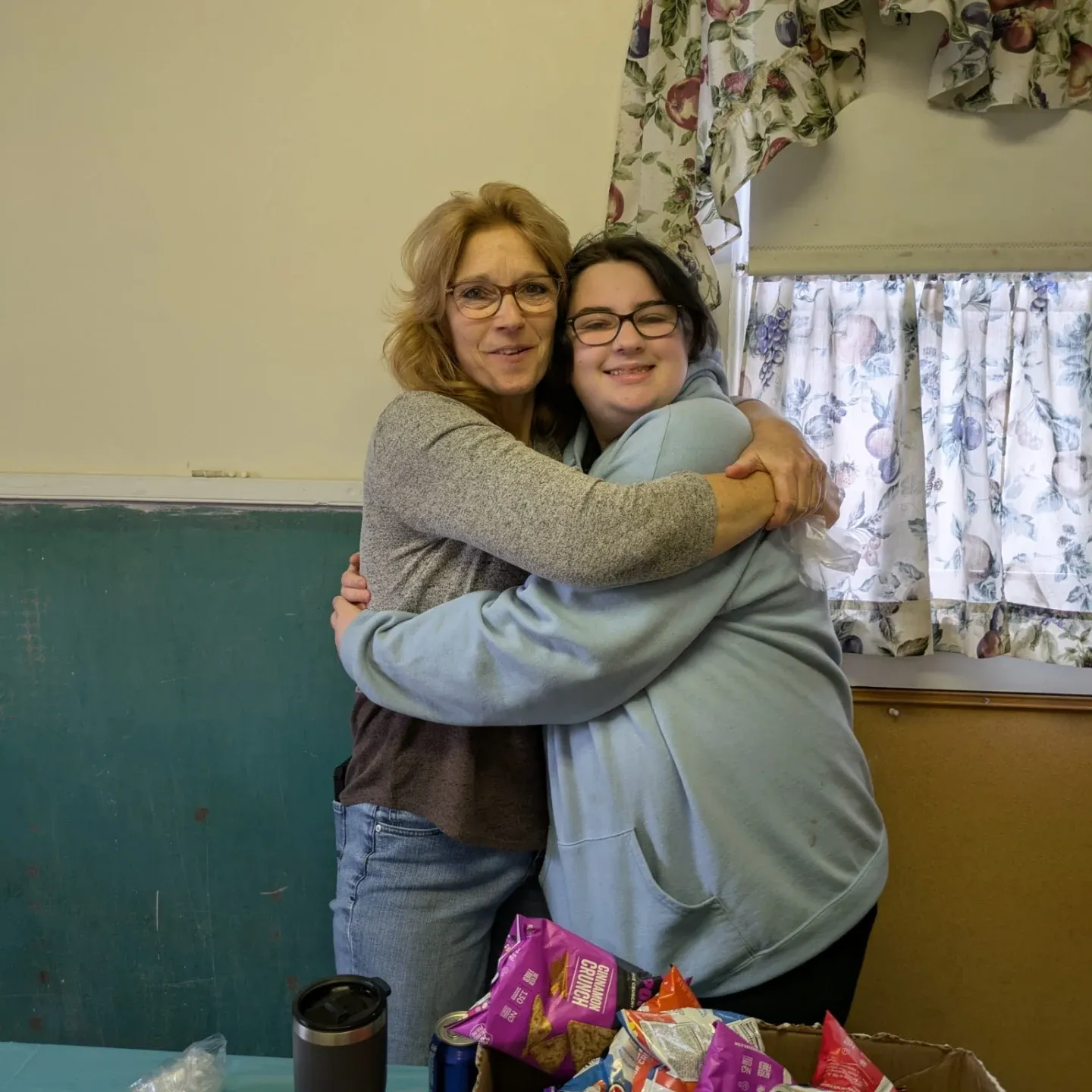 Two members of the McKees Rocks Assembly family sharing a hug