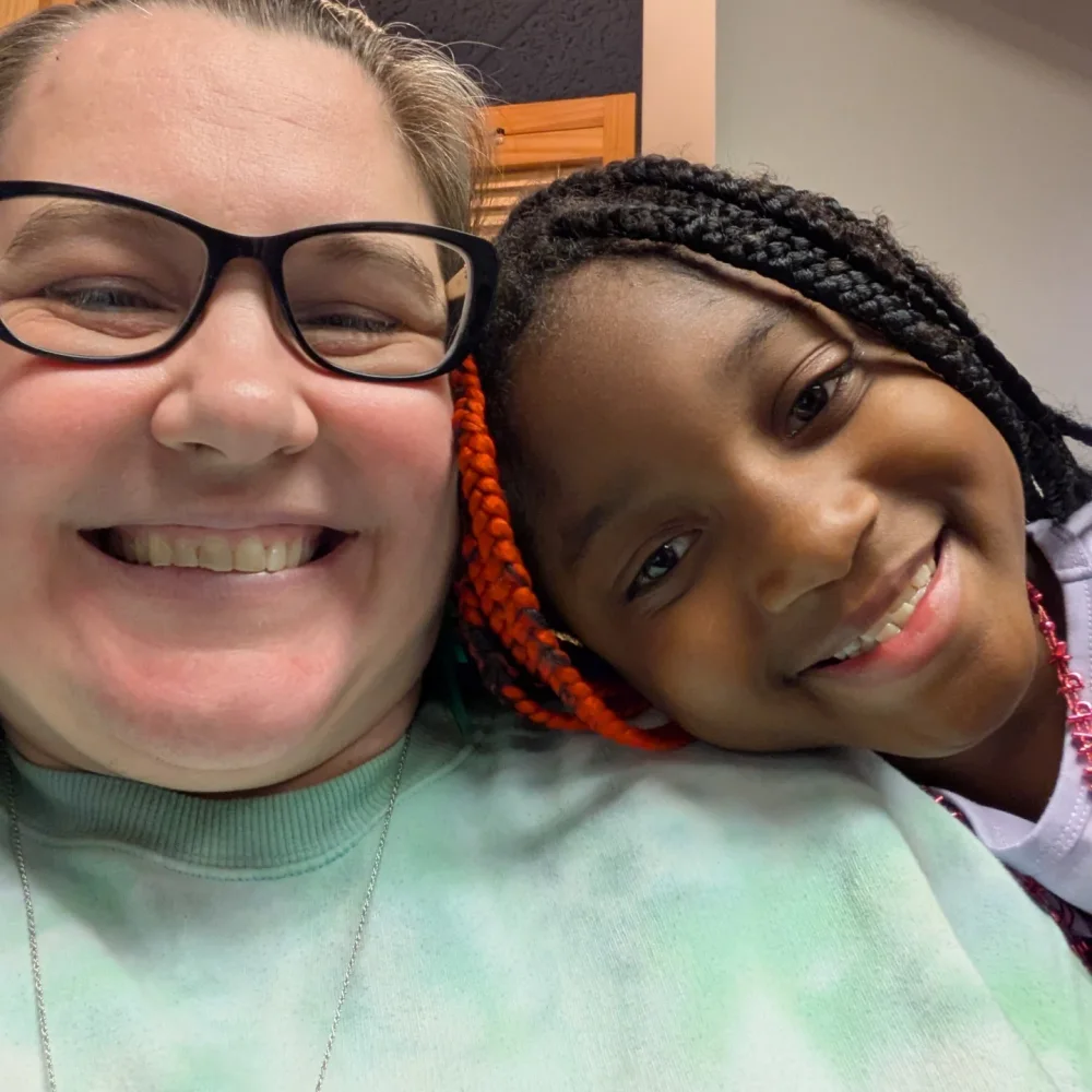 A leader and child smiling together at Kids Church